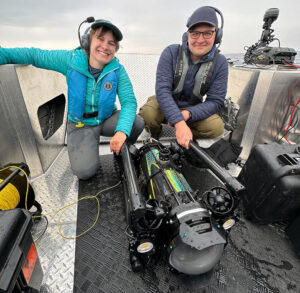 Yvonne and Zach on a boat with an underwater drone
